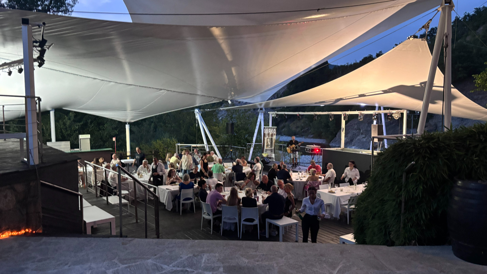 Ricevimento serale sotto la copertura con tavoli apparecchiati